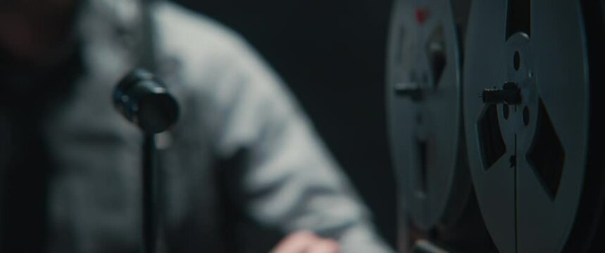An man listening to the recording with the attention and then rewinds the tape