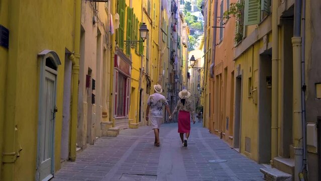 colorful old town of Menton on the French Riviera France during sunset. A diverse couple of men and women visiting Menton France Europe during the European summer