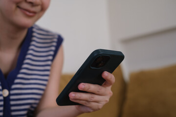 Close-up shot of an woman hand using her smartphone, chatting with someone or scrolling on her phone while relaxing. online communication technology concept.	
