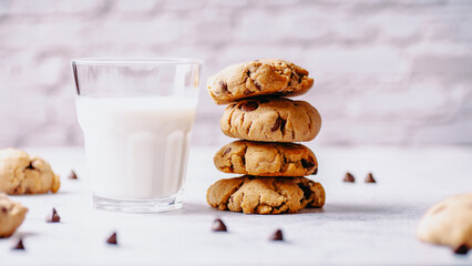 Chocolate chip cookies and a glass of milk on a light background