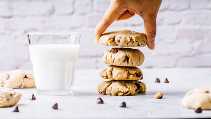 Chocolate chip cookies and a glass of milk on a light background - obrazy, fototapety, plakaty