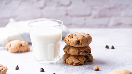Chocolate chip cookies and a glass of milk on a light background
