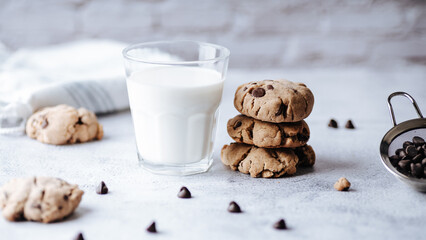 Chocolate chip cookies and a glass of milk on a light background