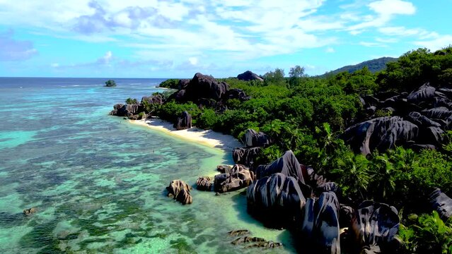 Anse Source d'Argent beach La Digue Island Seychelles, couple men and woman walking at the beach at a luxury vacation at the Seychelles
