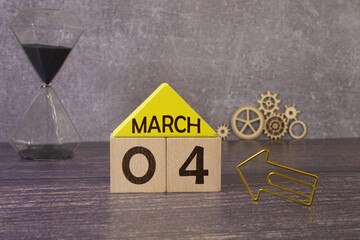 March 4 calendar date text on wooden blocks with blurred park background. Copy space and calendar...