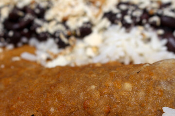 breaded meat with rice and beans on blurred background. meal with selective focus. food details. food texture.