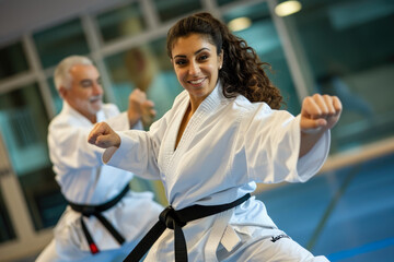 man and a woman practicing martial arts, with a black belt around their waists