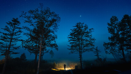 星が瞬く早朝にライトをつけて尾瀬ヶ原へと出発する登山者２
