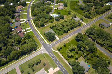 Fototapeta na wymiar Aerial view of american small town in Florida with private homes between green palm trees and suburban streets in quiet residential area