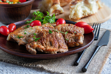 Pork chops. Close-up. On ceramic plate. Decorated with greenery. Hot meat dish. Healthy food, delicious homemade food.