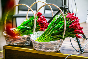 a red bouquet of roses in a wicker basket on the stage, an award in the form of red flowers
