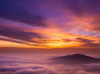 View from a mountain through the clouds. View from on airplane, at sunrise. Beautiful travel wallpaper. Orange dawn. Sense of freedom.