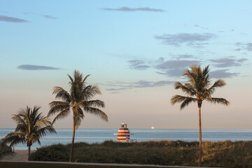 Obraz premium Miami Beach with palms and lighthouse, blue sky and blue ocean during the sunset