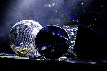 a reflective ball on the stage, a protective helmet in the background, two balls on the stage
