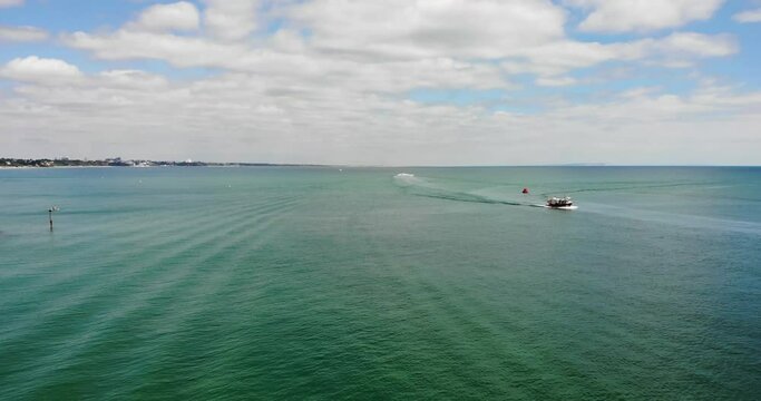 Low Flying Over English Channel Off Coast Of Sandbanks With Boat Going Sailing Past In Distance. Push Forward Shot