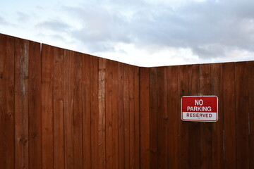 Wooden fence with no parking sign.