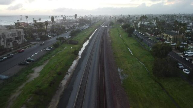 4k Drone Footage, COASTER Commuter Train Rides The Coast, sunset time, after rain, HQ, San Diego, 	Del Mar, Solana Beach, La Jolla, Encinitas, Carlsbad, Oceanside, Railroad crossings, city 