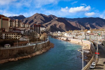 Scenic view of the upper stream of the Mekong River in Tibet, Qamdo, flanked by towering highrise...