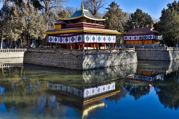 Scenic view of the Dragon King Palace nestled within the tranquil Norbulingka gardens, its majestic...