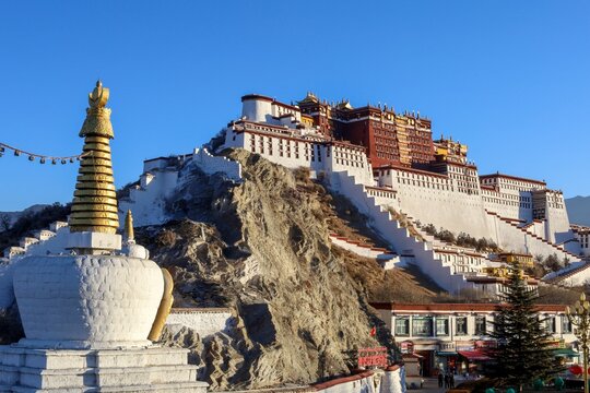 Capture the majesty of the Potala Palace, the historic winter residence of the Dalai Lama, as it stands proudly against the backdrop of Chakpori Hill in Lhasa, Tibet. 