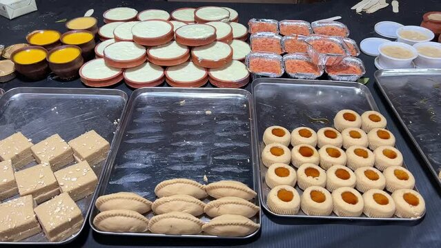 Cinematic view of many different kinds of traditional Bengali sweets kept as a display at a Sweet shop in Kolkata, India. No Face.