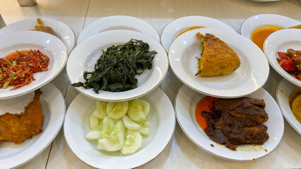 A line plate of various padang cuisine. One of the most popular meals in Indonesia, a mix of rice...