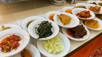 A line plate of various padang cuisine. One of the most popular meals in Indonesia, a mix of rice...