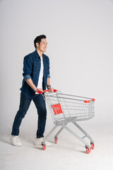 Happy smiling man pushing supermarket cart isolated on white background © Q88