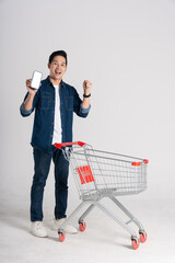 Happy smiling man pushing supermarket cart isolated on white background