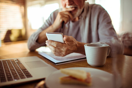 Senior Man Using A Phone At Home