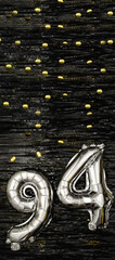 Silver foil balloon number ninety-four. Birthday or anniversary card with the inscription 94. Black...