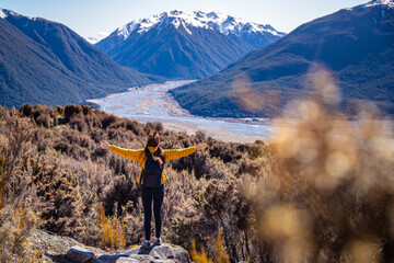 hiker girl walking on a bealey spur track in arthur's pass national park, canterbury, new zealand; hiking on a scenic track in new zealand alps