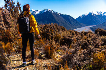 hiker girl walking on a bealey spur track in arthur's pass national park, canterbury, new zealand; hiking on a scenic track in new zealand alps