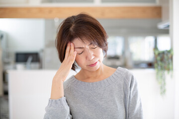 片頭痛に悩む日本人のミドル女性 - obrazy, fototapety, plakaty