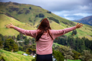 pretty hiker girl enjoys the idyllic landscape of banks peninsula near akaroa, canterbury, new zealand