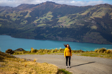 pretty hiker girl enjoys the idyllic landscape of banks peninsula near akaroa, canterbury, new zealand