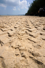Texture of motor vehicle tire tracks on the beach. View of car tire tracks on the beach sand
