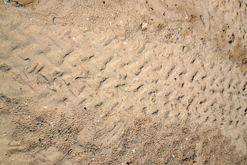 Texture of motor vehicle tire tracks on the beach. View of car tire tracks on the beach sand
