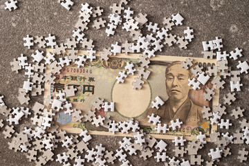 Japanese banknotes and jigsaw puzzle pieces	
