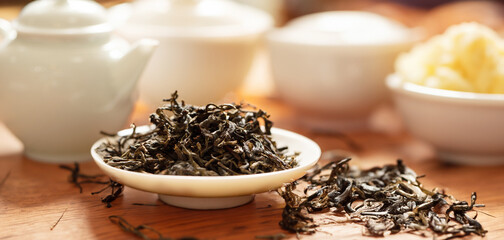 Dried tea and pottery set on bamboo board
