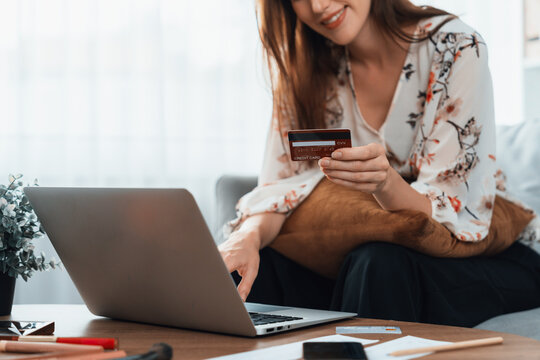 Young happy woman buy product by online shopping at home while ordering items from the internet with credit card online payment system protected by utmost cyber security from online store platform