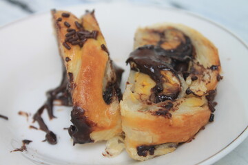Slices of Chocolate Banana Strudel sprinkled with chocolate sprinkles in a white plate on the table