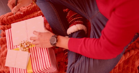 Person wrapping Christmas gifts at home, with copy space