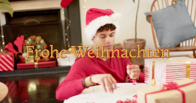 Image of frohe wihnachten text over caucasian man wrapping presents at christmas