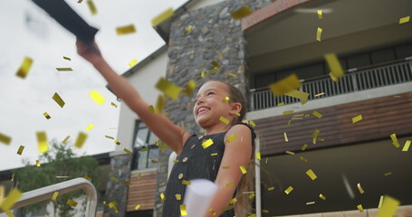 Image of gold confetti over celebrating caucasian schoolgirl throwing mortar board in air