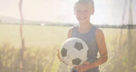 Foto op Plexiglas Image of plants and sunlight over happy caucasian schoolboy with football in field © vectorfusionart