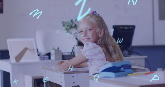 Image of letters over smiling caucasian schoolgirl working in class