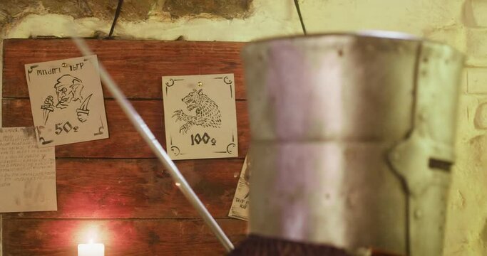 Warrior tears paper of bulletin board in tavern. Medieval knight takes task to catch monster for money on pin-board in pub. Assassin in armour