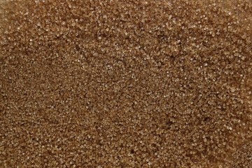 Granulated brown cane sugar as sweet food background, top view.
