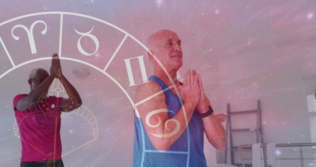 Image of horoscope icons over diverse group of seniors practicing yoga